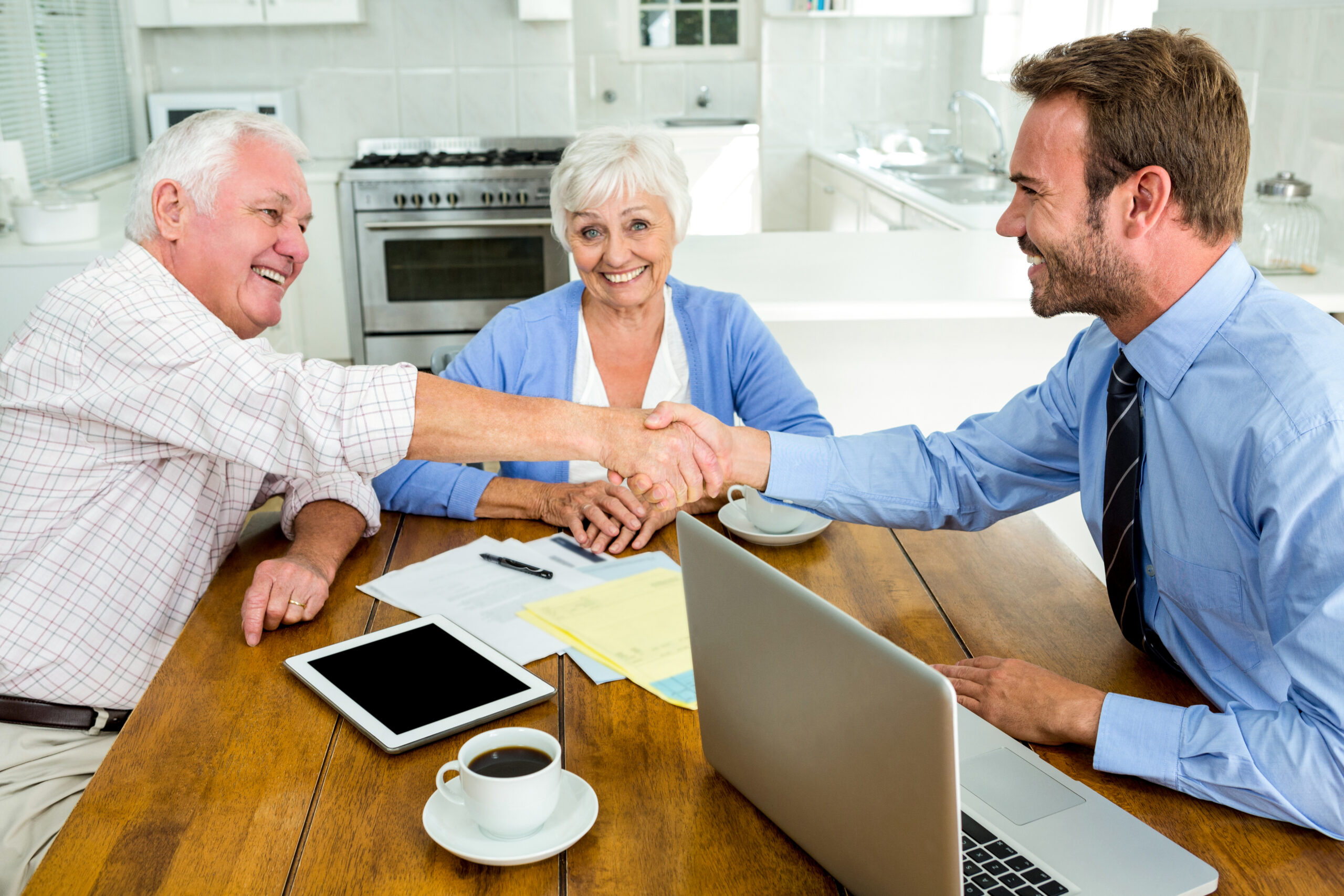 Happy senior man handshaking with agent