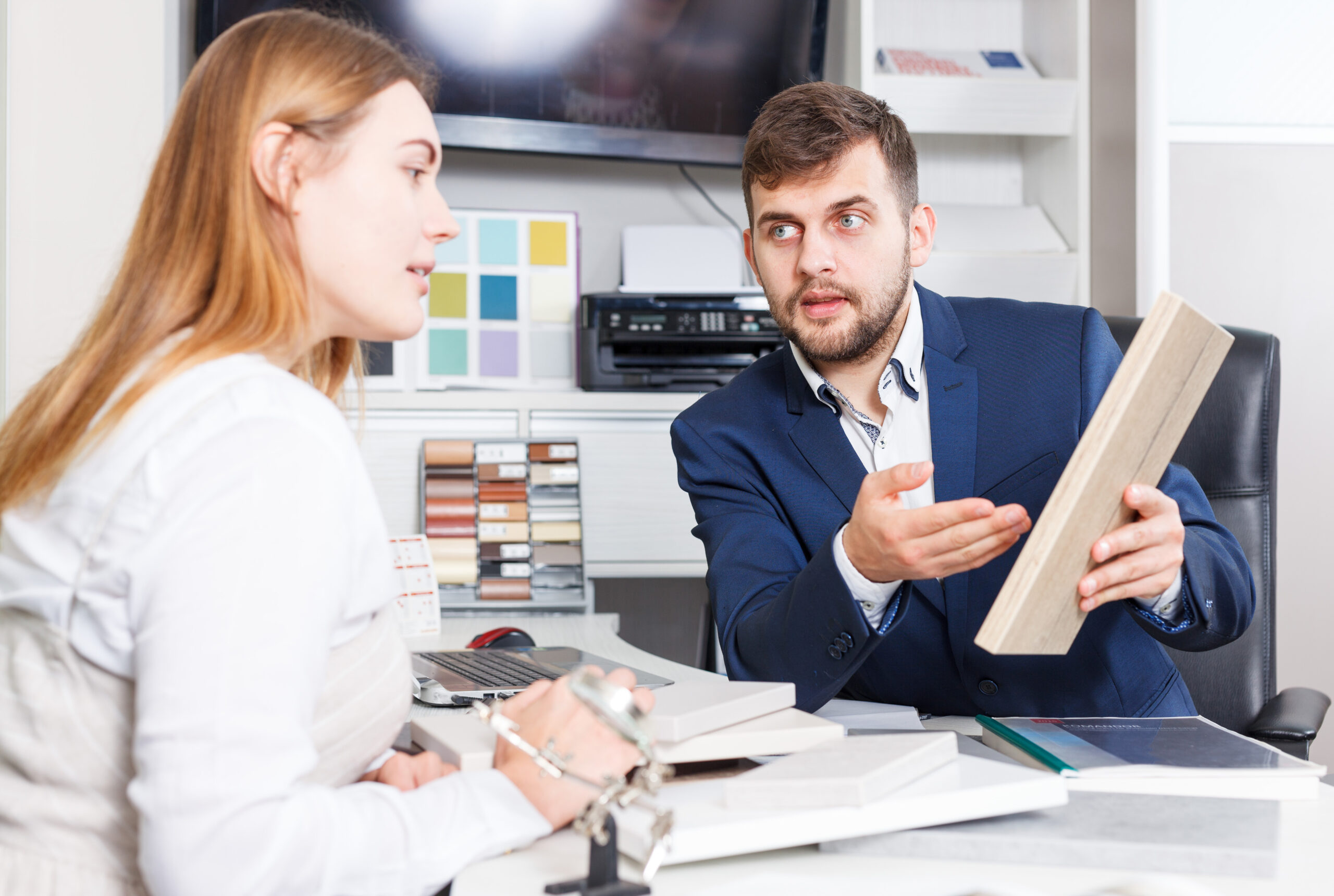 Woman with salesman choosing material for furniture